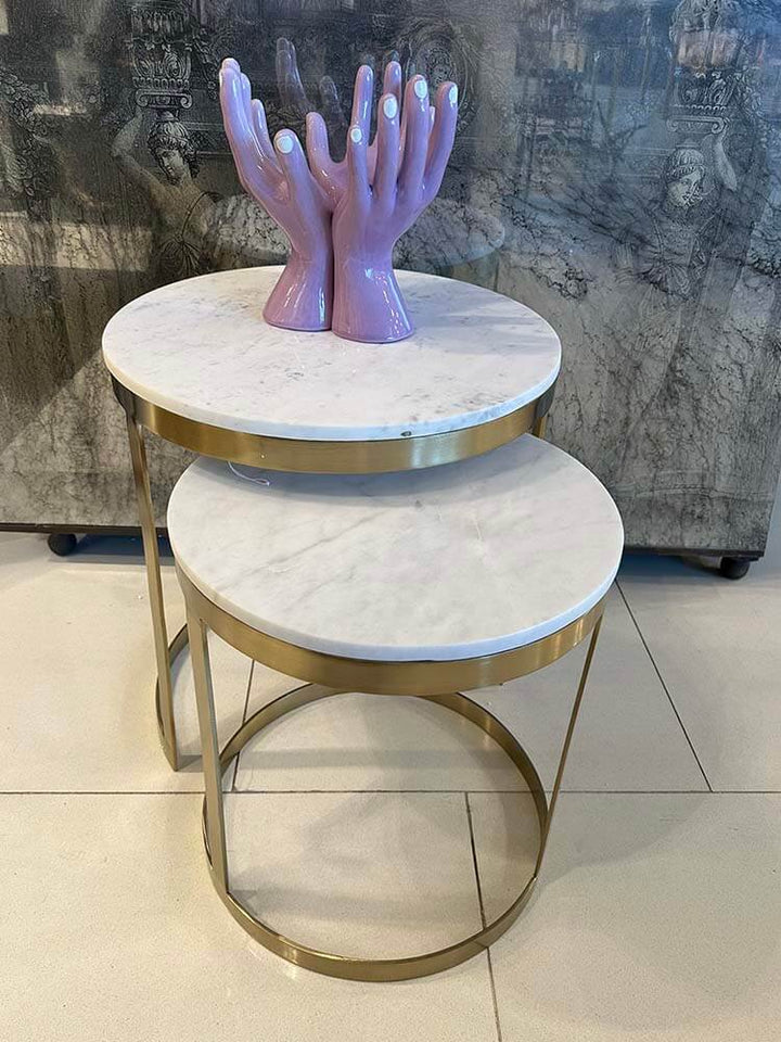 A set of two side tables featuring natural marble tops in white and gold